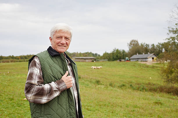 istock Senior Caucasian Man Smiling While Standing Outdoors on Rural Farm Field 2239001648