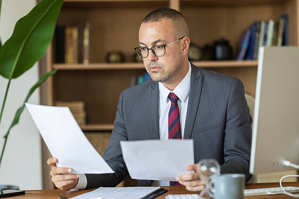 istock Businessman reviewing documents in office, focusing on important paperwork 2239001697