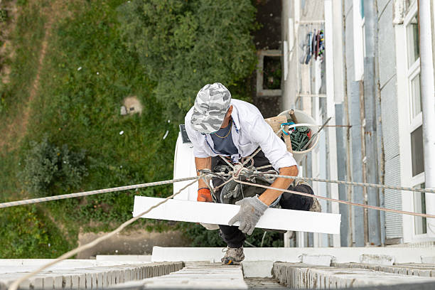 istock Construction worker insulating the exterior wall of a building with polystyrene panels at height. 2239005838