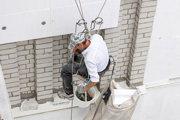 istock Construction worker insulating the exterior wall of a building with polystyrene panels at height. 2239006292