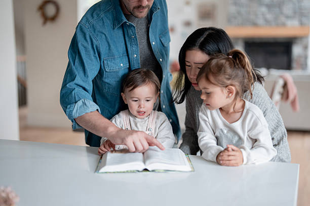 istock Family Reading Time: Asian Mother, White Father Help Two Young Children Learn At Home Together 2239006377