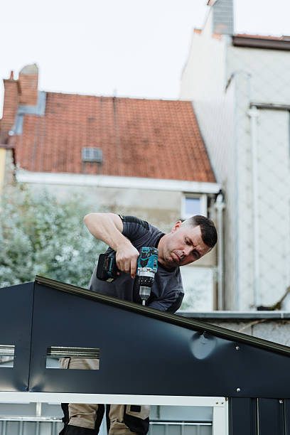 istock Mature handyman installing roofing sheets with drill on metal shed. 2239006545