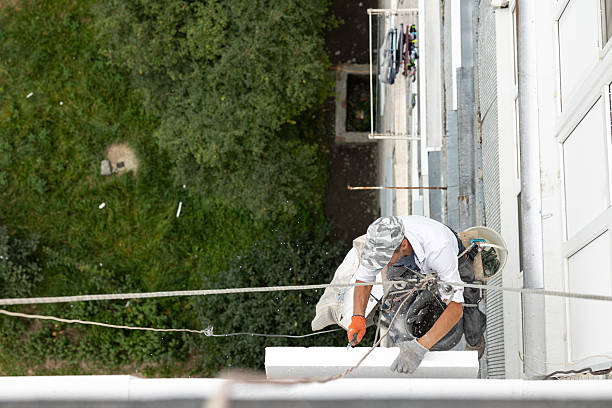 istock Construction worker insulating the exterior wall of a building with polystyrene panels at height. 2239007339