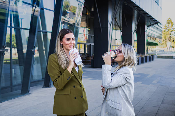 istock Female colleagues chatting while walking on coffee break outside  corporate office building, 2239013903