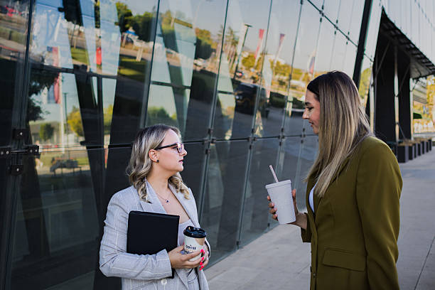 istock Female colleagues chatting while walking on coffee break outside  corporate office building, 2239014195