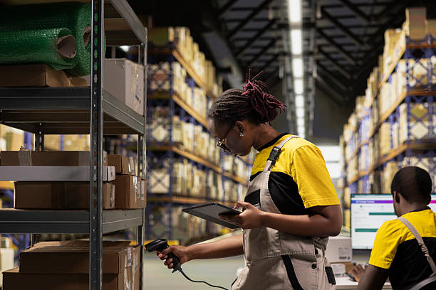 istock Black female staff using scanner checking airway bill numbers in inventory 2239014450