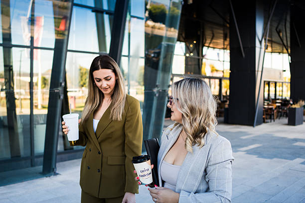 istock Female colleagues chatting while walking on coffee break outside  corporate office building, 2239015256