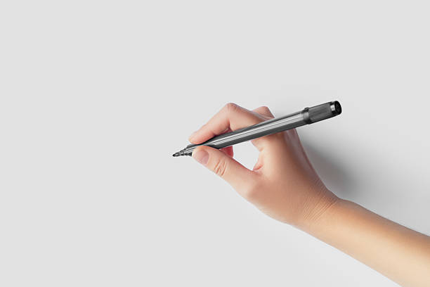 istock Hand Holding a Black Marker on White Paper 2239022787