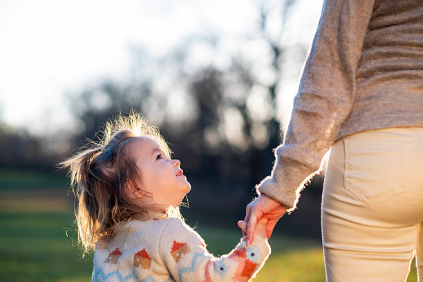 istock Child holding mother's hand outdoors feeling trust and love 2239033264