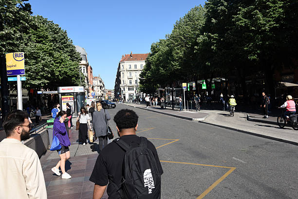 Toulouse Rue de Metz with several pedestrians close a bus stop. Captured on a sunny day during spring season.