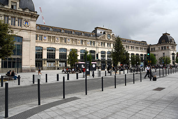 Toulouse-Matabiau is the main railway station in Toulouse, southern France. The current passenger building was built between 1903 and 1905. The image shows the station building with some peple captured during spring season.
