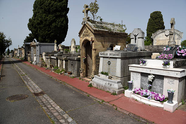 Terre-Cabade Cemetery in Toulouse stands as the largest cemetery in the region, sprawling across a 33-hectare area on the Jolimont hillside. The oldest part of the Cemetery was realized in 1840. The image shows several graves, captured during spring season.