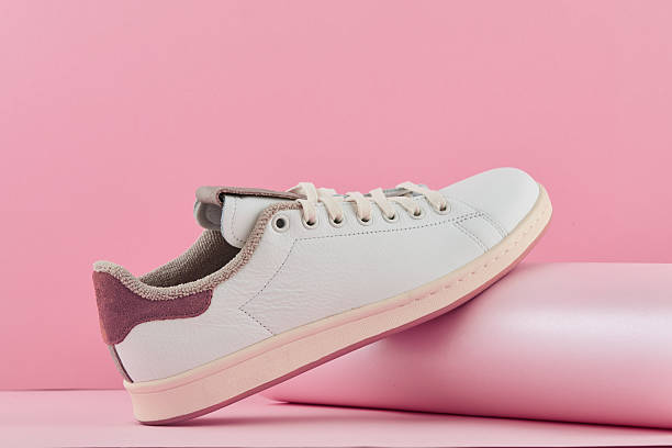 istock Minimalist white sneaker featuring brown details, resting on soft pink surface, embodying contemporary streetwear aesthetic 2239035364