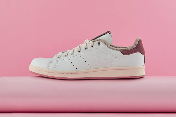 istock Minimalist white sneaker featuring brown details, resting on soft pink surface, embodying contemporary streetwear aesthetic 2239035371