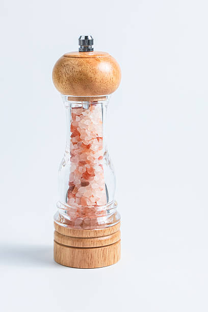 Elegant salt grinder with wooden base showcases pink Himalayan salt crystals