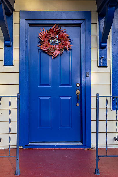 istock A artificial wreath with fall foliage on a bright blue door 2239046909