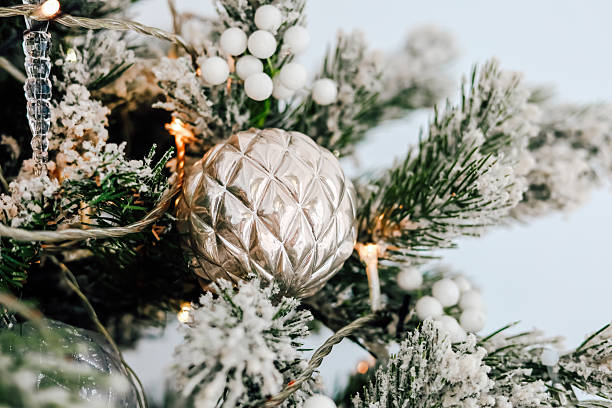 istock Decorative silver ornament on a snow covered Christmas tree branch with lights 2239047147