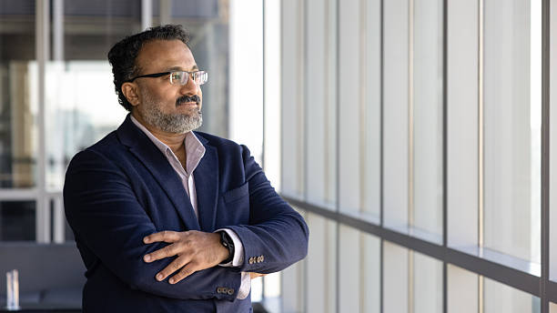 istock Positive Indian company executive man looking at large office window 2239048461