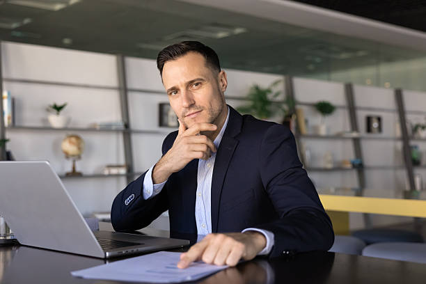 istock Confident handsome business professional man posing at workplace with laptop 2239048670