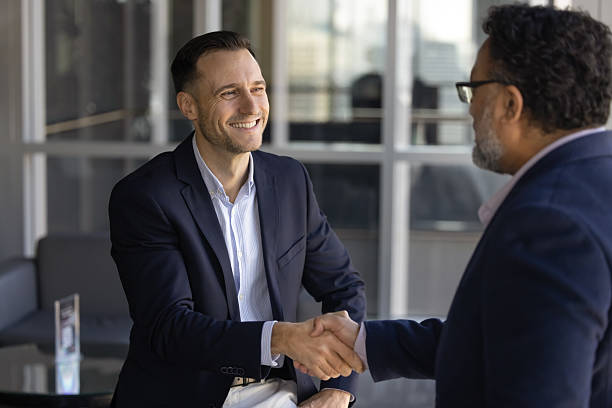 istock Happy consultant man shaking hands with older Indian male client 2239051282