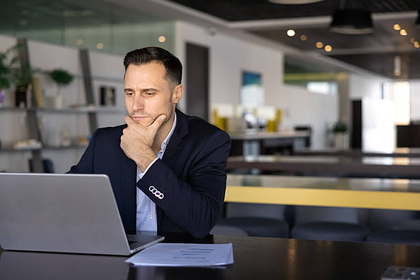 istock Serious young Latin businessman working at computer 2239056692