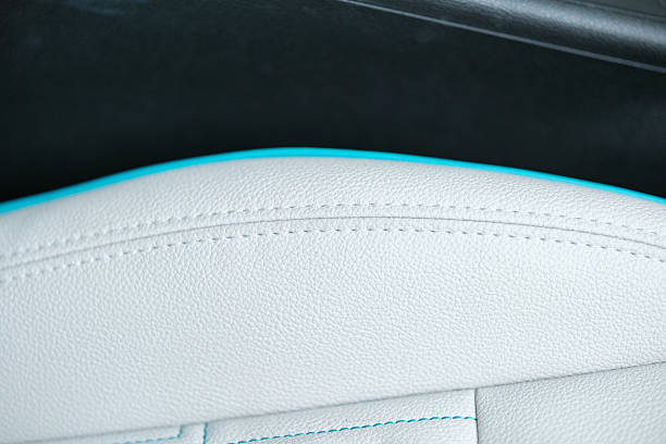 Close up view showcasing white leather seat with intricate stitching and bright turquoise accents merging luxury with bespoke design
