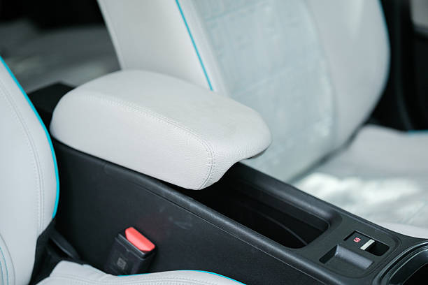 istock Car interior: Center console with a white leather armrest adjacent to seats with a matching white leather and blue trim 2239058070