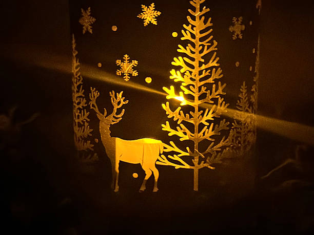 istock Christmas candle lantern with glowing light, deer, snowflakes and tree cutouts 2239058430