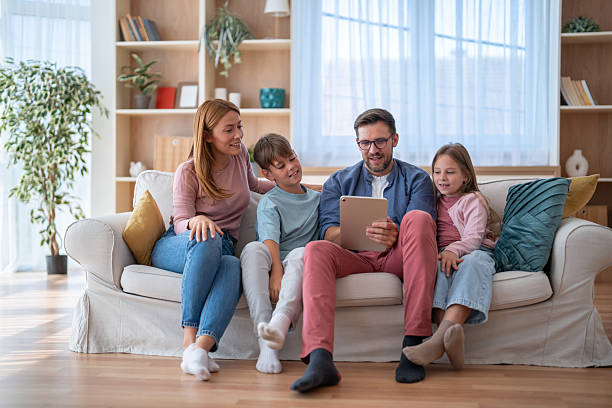 istock Family enjoying time together on the sofa looking at a tablet 2239068033