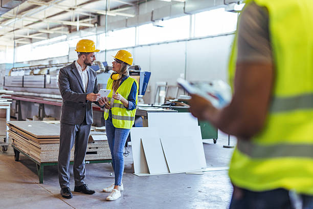 istock Professionals Reviewing Project Plans in a Modern Industrial Setting 2239068120