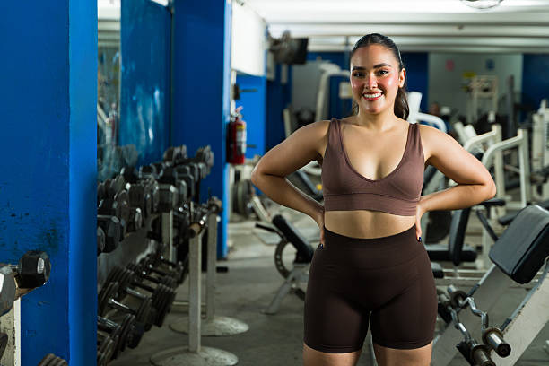 Young woman smiling confidently after intense strength training at the health club, radiating fitness, wellness and motivation