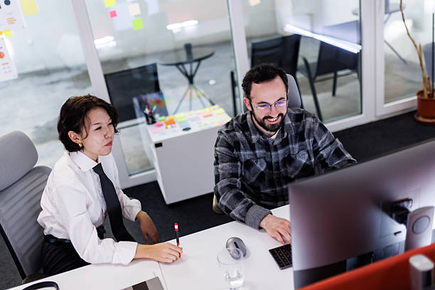 istock Business professionals collaborate on a project in a modern office during working hours, utilizing technology to enhance productivity and teamwork 2239070413