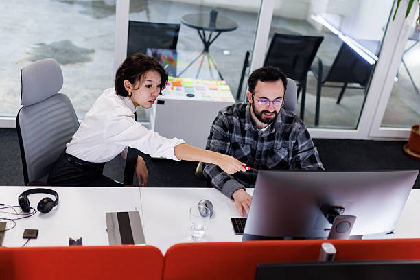 istock Business professionals collaborate in a modern office setting as they discuss project details on a computer screen during a productive work session 2239070425