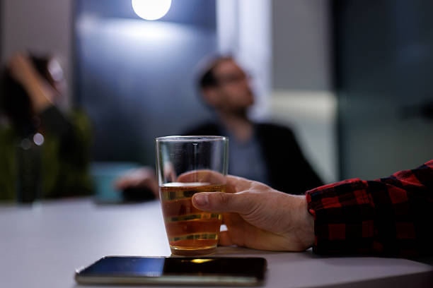 istock Group of business professionals engaging in discussion with drinks at a modern office setting during an evening networking event 2239070487