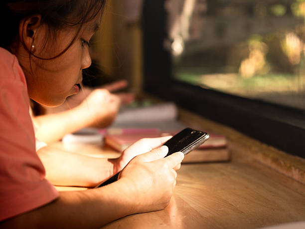 istock Focused girl using smartphone for learning by the window 2239078994