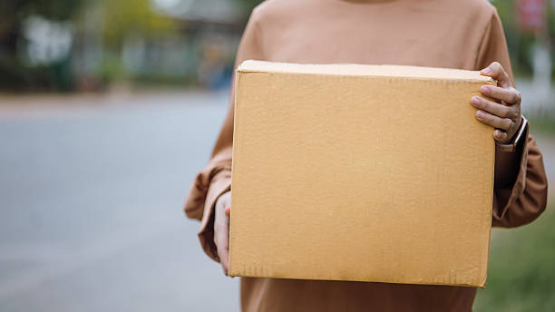 istock Courier Holding Cardboard Box Outdoors for Shipping and E-commerce Delivery 2239089917