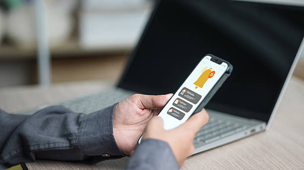 istock Mobile Notifications and Alert Badges on Smartphone beside Laptop 2239090007