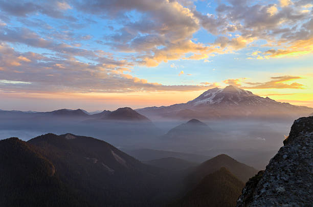 Sunset warms the slopes of majestic Mount Rainier and surrounding valleys.