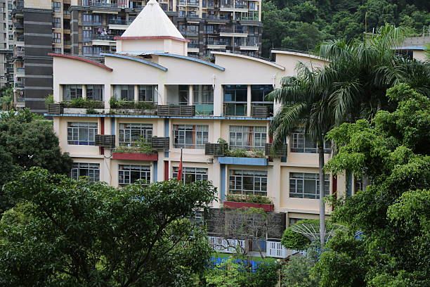 The building has a red roof and a green roof. The building is tall and has many windows. The windows are arranged in a way that allows for natural light to enter the building