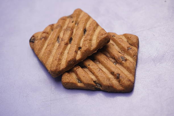 Stacked Chocolate chip cookies on an orange background. Top-down view. Food Flat lay.