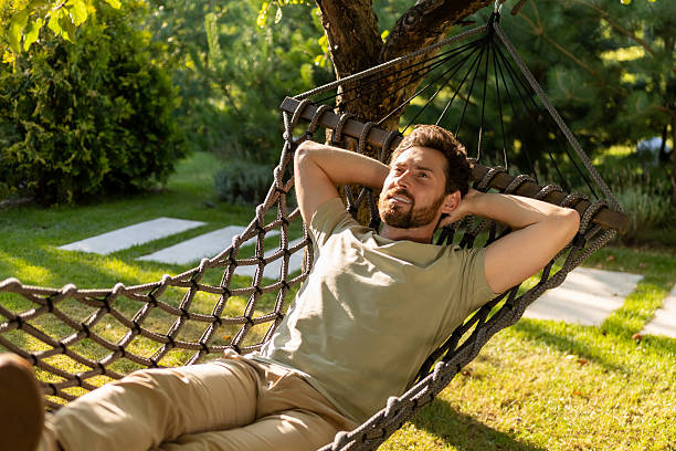 istock Bearded young man lying in a hammock and feeling relaxed 2239108271