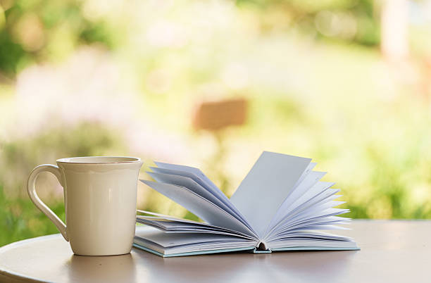 A serene moment with an open book and a cup set against a softly blurred background, capturing calm, cozy and reflective vibes.
