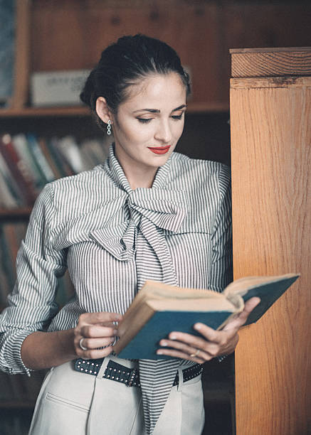 istock Young vintage university student studying in an old-fashioned library leaning against a bookshelf 2239109293