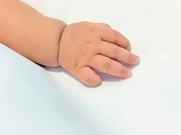 istock Baby Hand Close Up on Soft White Background 2239111324