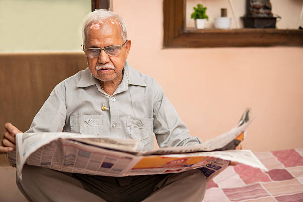 istock Senior Indian man reading newspaper in leisure time at home. 2239125821