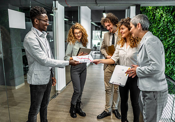 istock Business team discussing charts in modern office hallway 2239127541