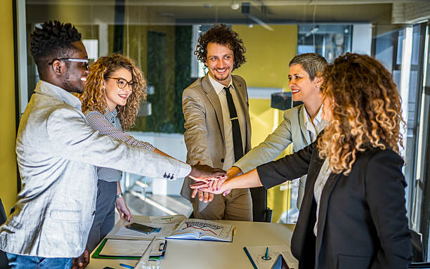 istock Business team stacking hands in office showing unity and collaboration 2239127596