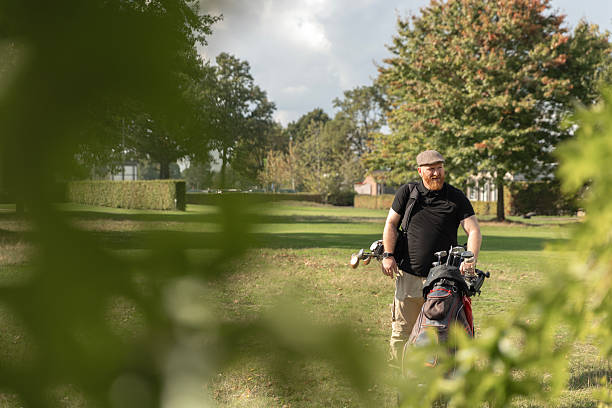 A man is swinging a golf club high above head on a vibrant green golf course