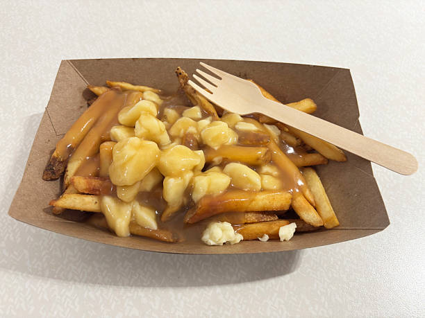 istock The classic Canadian dish poutine in a cardboard bowl with a wooden fork. 2239135564