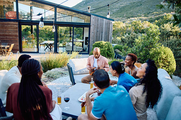 istock Group of diverse young adults enjoying drinks and relaxation outdoors at scenic modern vacation cabin with lush greenery 2239142879